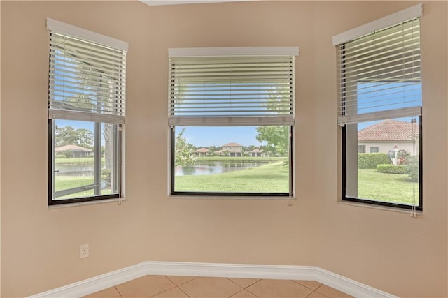 tiled spare room with a water view