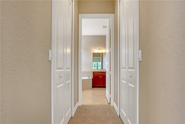 hall with light colored carpet