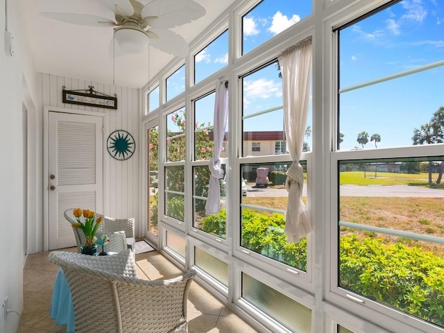 sunroom with tile patterned flooring and ceiling fan
