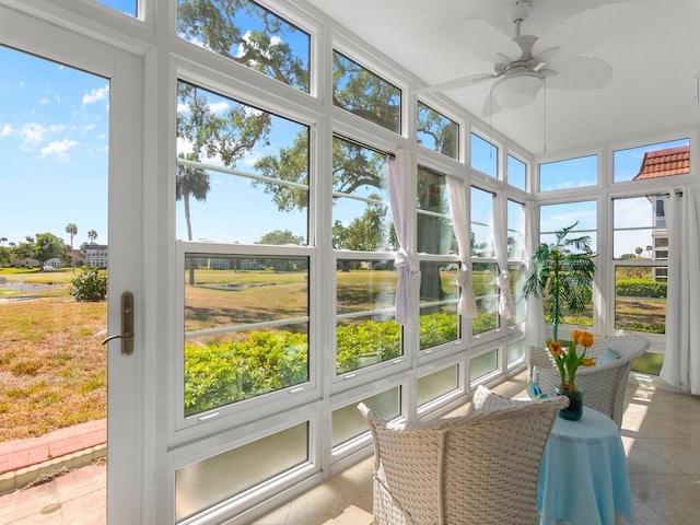 sunroom with ceiling fan and tile patterned floors