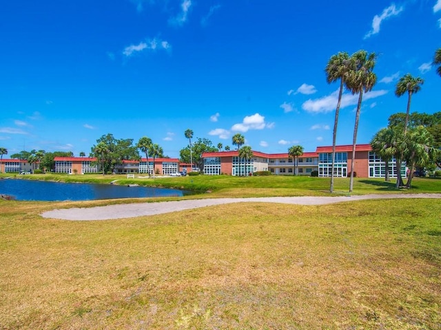 view of home's community with a lawn and a water view