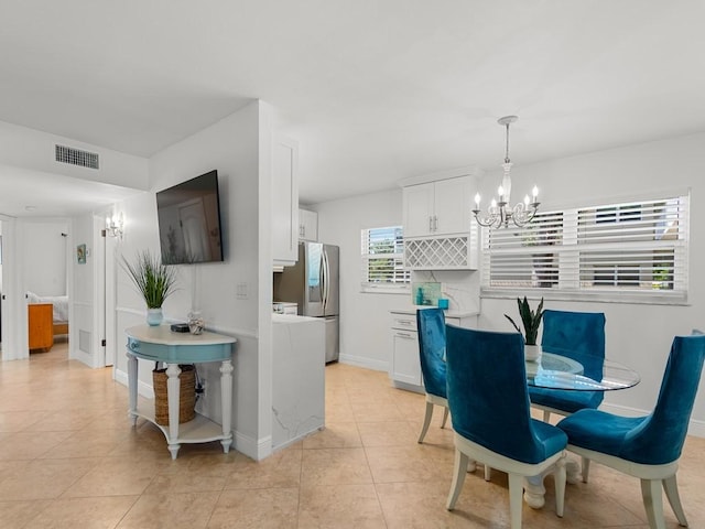 dining space with visible vents, baseboards, light tile patterned floors, and a chandelier