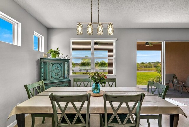 2158 Hawk River Dr SW, Vero Beach, FL 32962 - dining area featuring a textured ceiling, baseboards, ceiling fan, a chandelier, and a water view