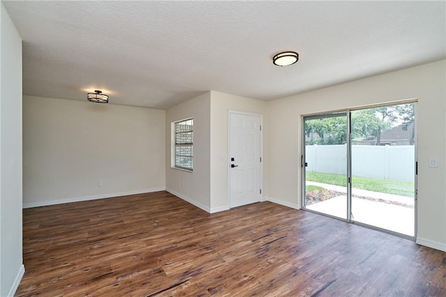 interior space featuring baseboards, dark wood-style flooring, and a textured ceiling