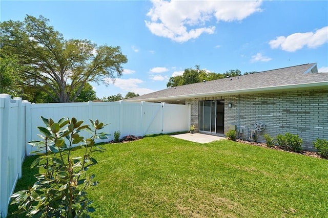 rear view of property with brick siding, a lawn, a fenced backyard, and a gate