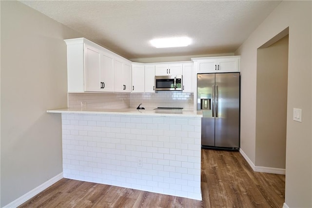 kitchen with appliances with stainless steel finishes, dark wood-style flooring, and light countertops