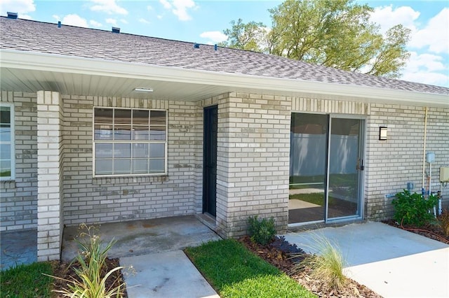 property entrance featuring a shingled roof