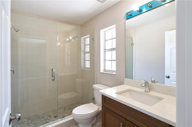 full bathroom featuring vanity, toilet, and a stall shower