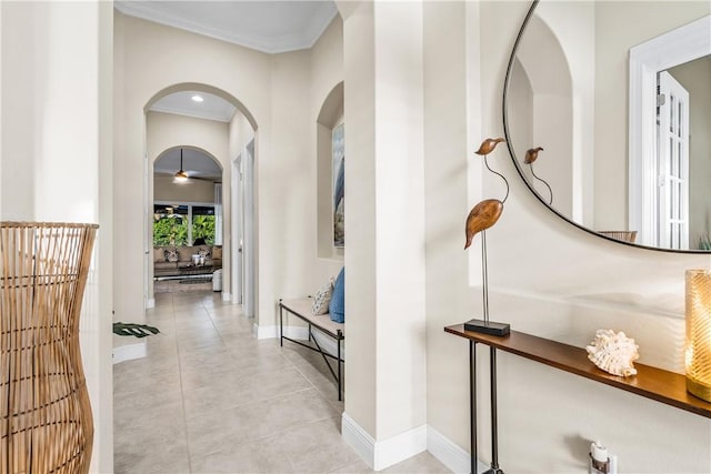 corridor with light tile patterned floors and crown molding