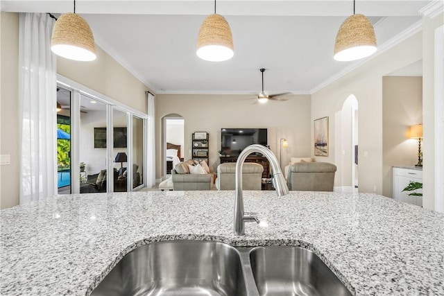 kitchen featuring sink, hanging light fixtures, and ornamental molding