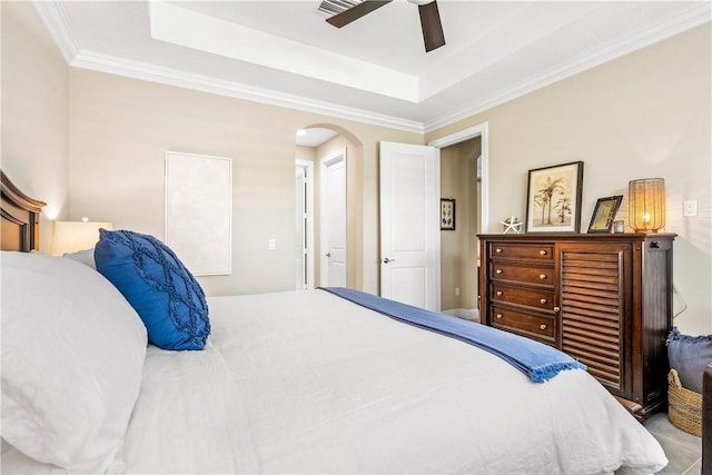 bedroom featuring a raised ceiling, ceiling fan, and ornamental molding