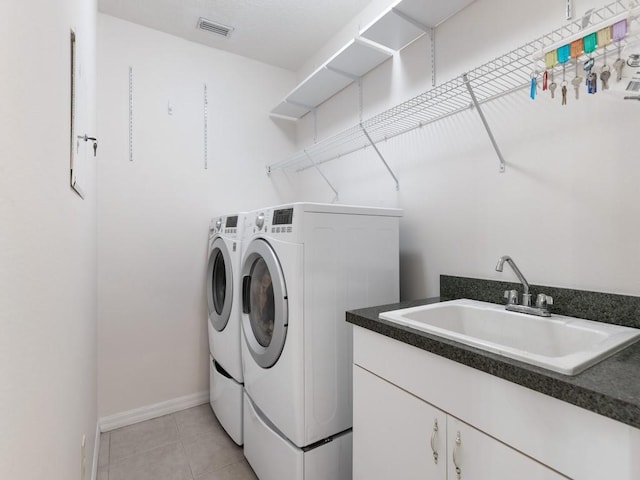 laundry area with cabinets, independent washer and dryer, light tile patterned floors, and sink