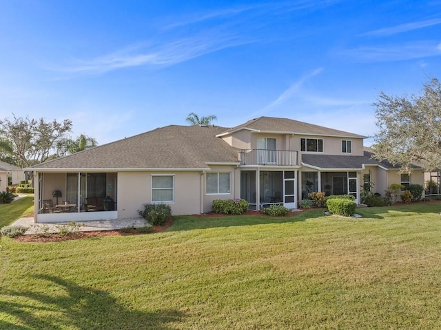 back of property featuring a lawn, a sunroom, and a balcony