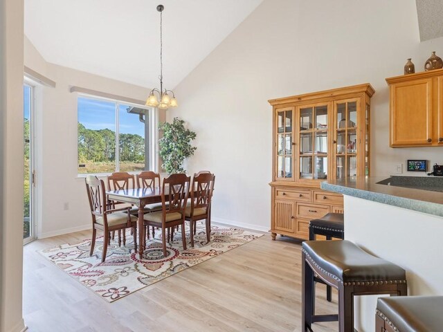 dining room featuring light hardwood / wood-style flooring, a chandelier, and a high ceiling