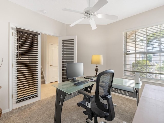 home office featuring light carpet and ceiling fan