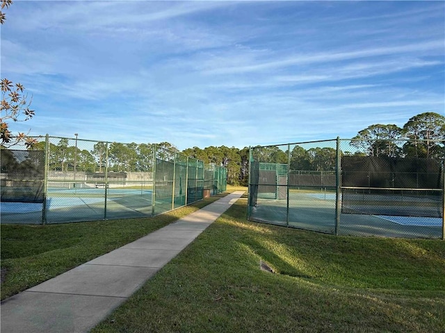 view of tennis court featuring a yard