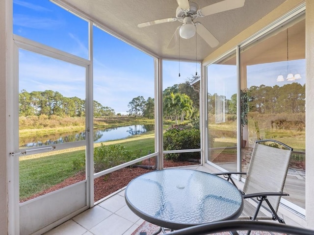 sunroom / solarium with a wealth of natural light, a water view, and ceiling fan