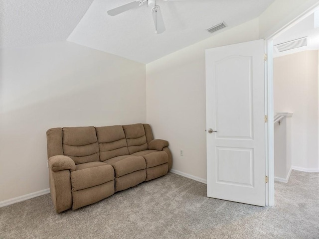 living room featuring ceiling fan, light carpet, and vaulted ceiling