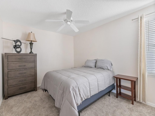 carpeted bedroom with multiple windows, a textured ceiling, and ceiling fan