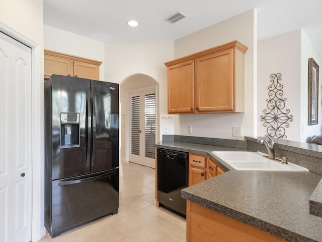 kitchen with light tile patterned floors, sink, a textured ceiling, and black appliances