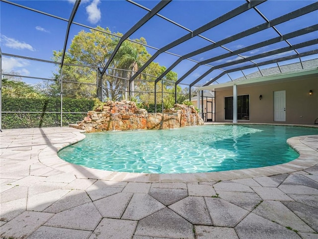 view of pool featuring glass enclosure and a patio area