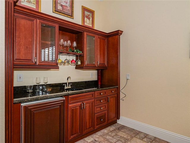 bar with sink and dark stone counters