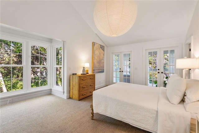 carpeted bedroom with french doors, lofted ceiling, and access to exterior