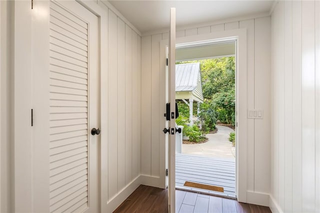 doorway featuring dark wood-style floors and baseboards