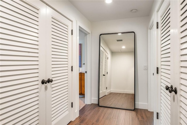 hallway featuring recessed lighting, wood finished floors, visible vents, and baseboards