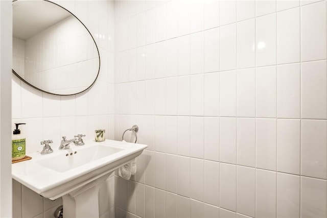 bathroom with a sink and tile walls