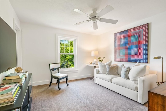 living room featuring a ceiling fan, light colored carpet, and baseboards