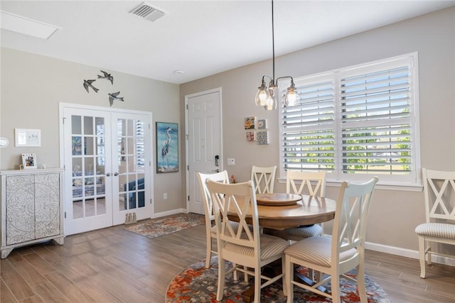 dining area with french doors, wood finished floors, and visible vents