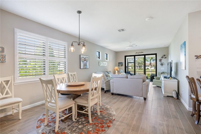 dining room with light wood-style floors, visible vents, and baseboards