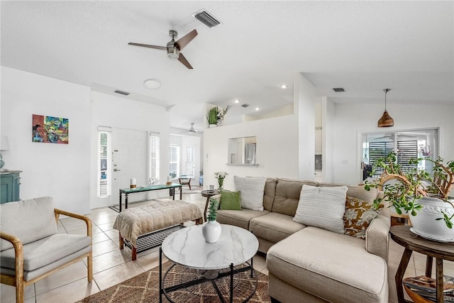 living area with lofted ceiling, light tile patterned flooring, and visible vents