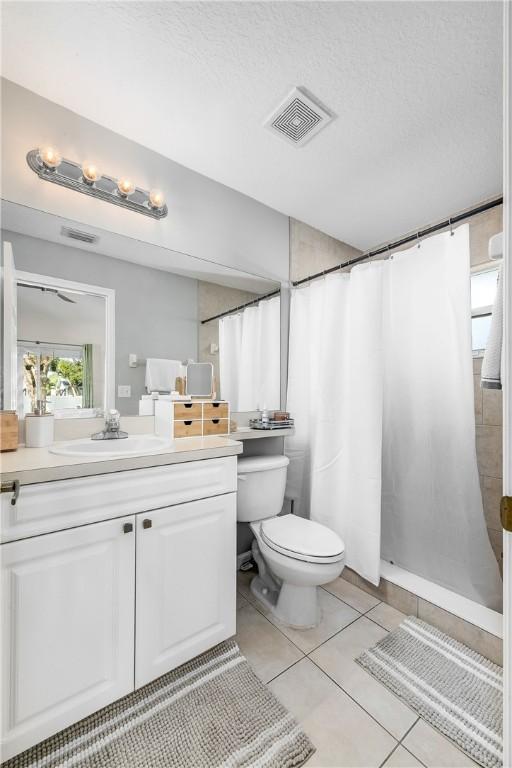 bathroom with visible vents, toilet, tile patterned floors, a textured ceiling, and vanity