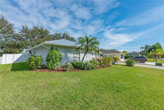 view of home's exterior featuring a lawn, fence, and stucco siding