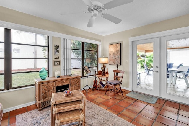 sunroom featuring french doors and a ceiling fan