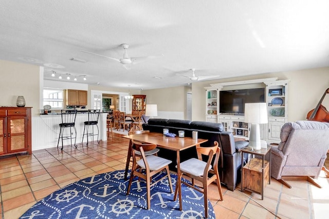 dining area with light tile patterned flooring, ceiling fan, and a textured ceiling