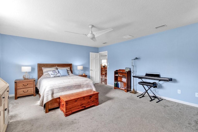 carpeted bedroom with a textured ceiling, ceiling fan, visible vents, and baseboards