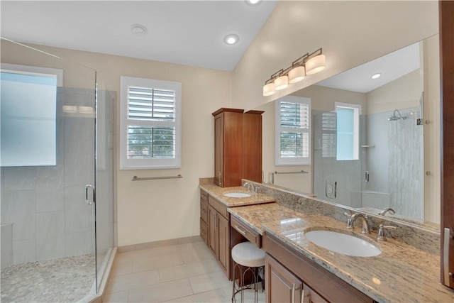 bathroom featuring tile patterned flooring, vanity, vaulted ceiling, and walk in shower