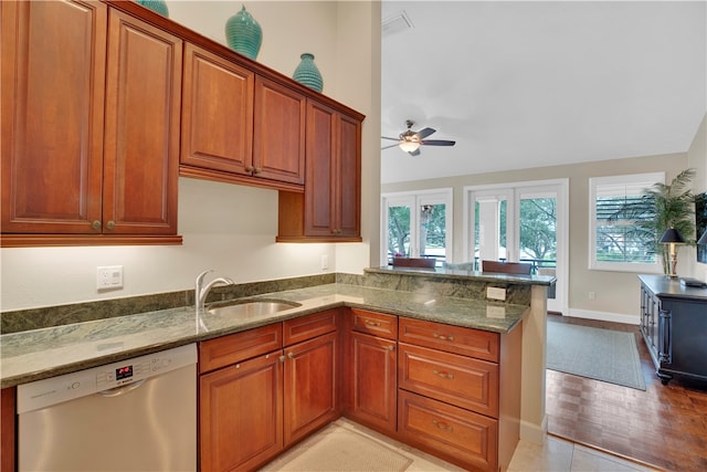 kitchen featuring light stone counters, stainless steel dishwasher, plenty of natural light, and kitchen peninsula