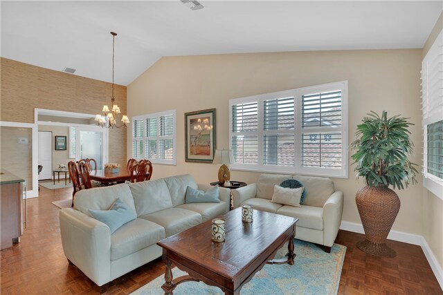 living room with high vaulted ceiling, parquet flooring, a wealth of natural light, and an inviting chandelier