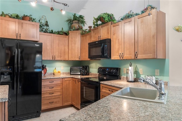 kitchen with light stone countertops, sink, light tile patterned floors, and black appliances