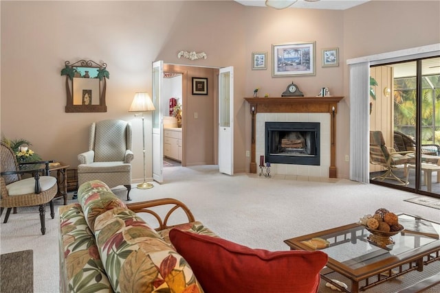 carpeted living room featuring a towering ceiling and a tile fireplace