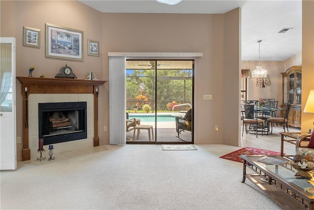 living room with carpet flooring, a fireplace, and a chandelier