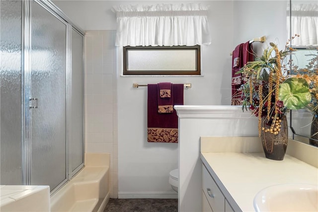 full bathroom featuring vanity, toilet, and bath / shower combo with glass door