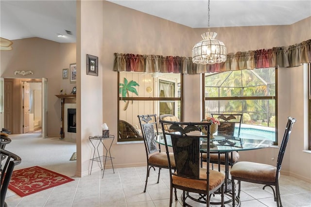 tiled dining area with an inviting chandelier and lofted ceiling