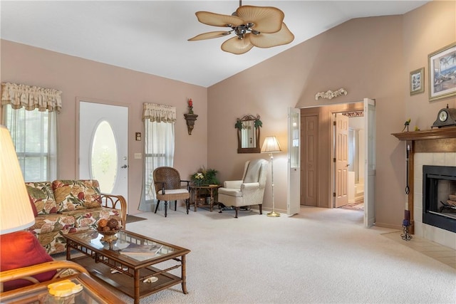 living room featuring a tile fireplace, light colored carpet, ceiling fan, and lofted ceiling