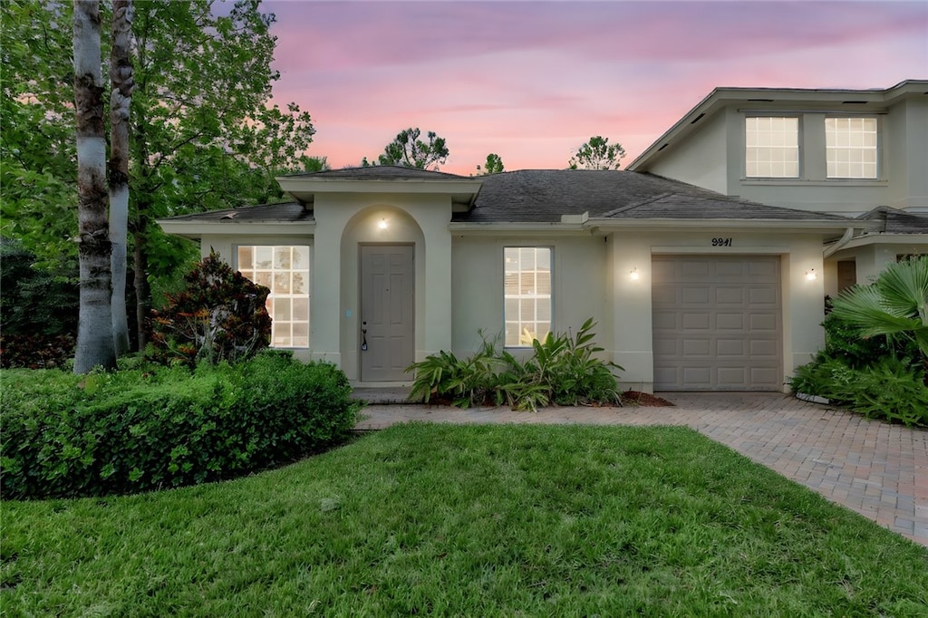 view of front of property featuring a garage and a yard