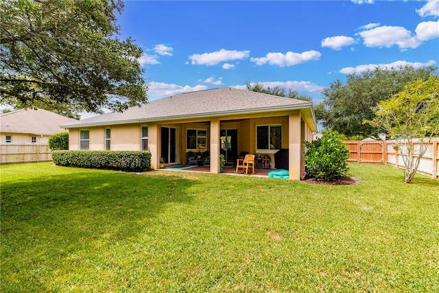 back of house featuring a patio and a yard